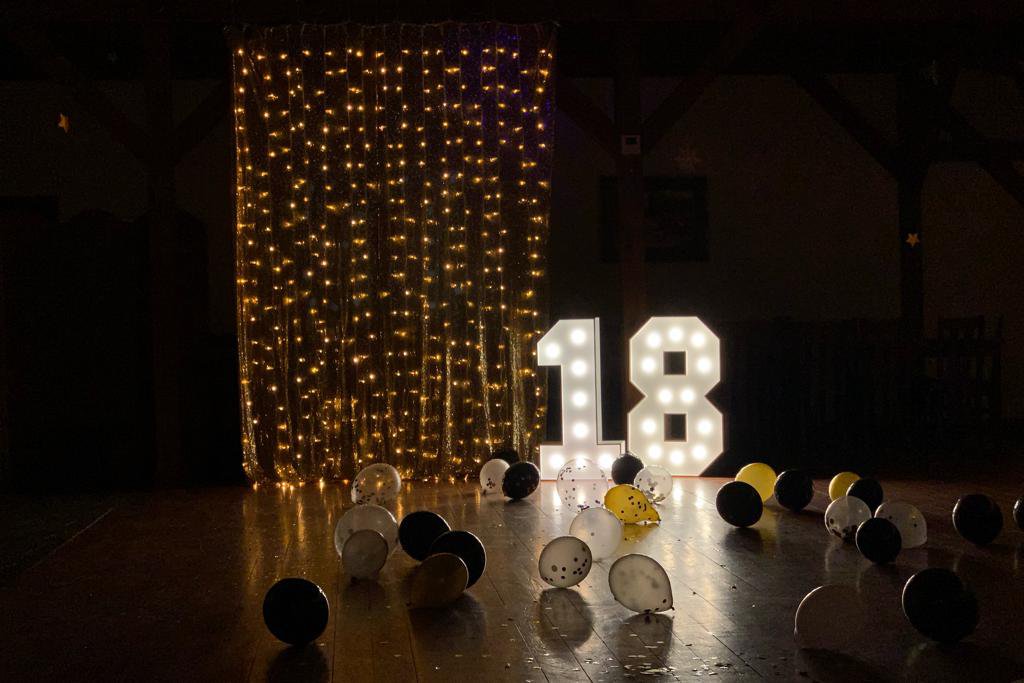 Cyfry 18 z żarówkami na nocnym tle - idealne na osiemnastkę