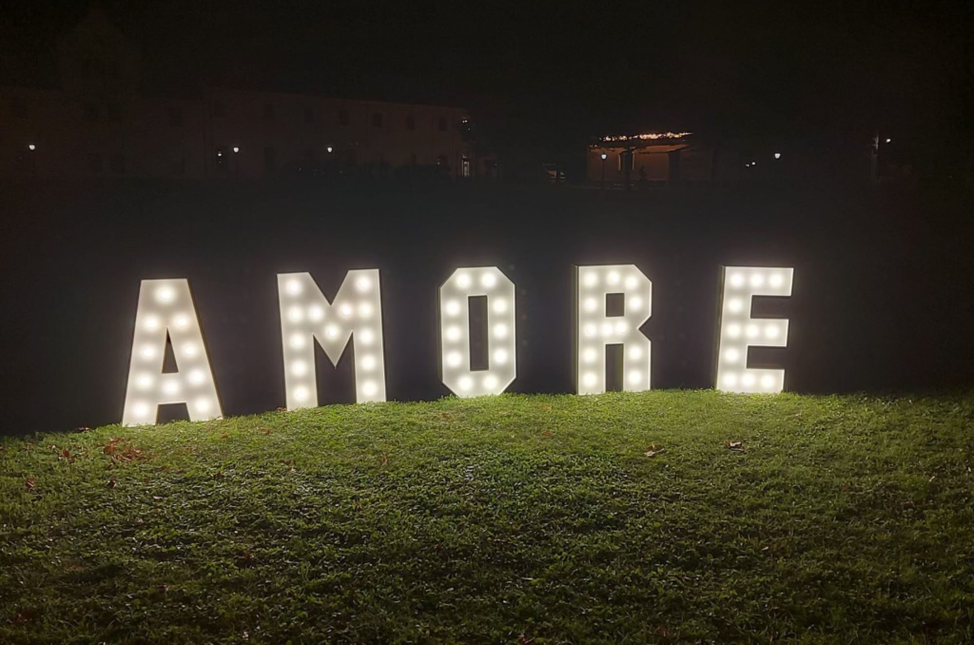 Żar&oacute;wkowy napis AMORE na dziedzińcu zamkowym &ndash; romantyczne tło do zdjęć; wynajem dekoracji weselnych